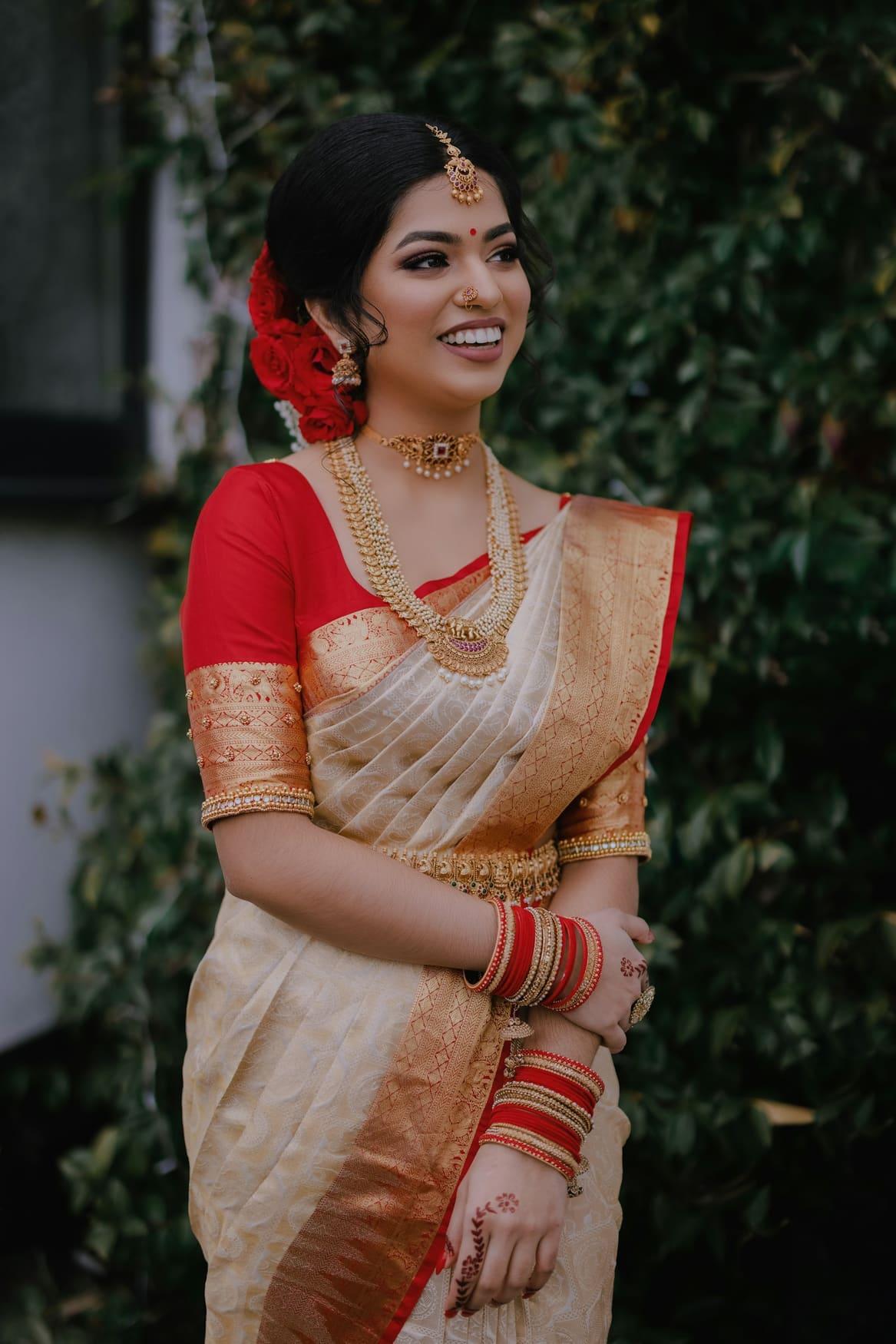 Woman in a white and red saree with a matching red blouse