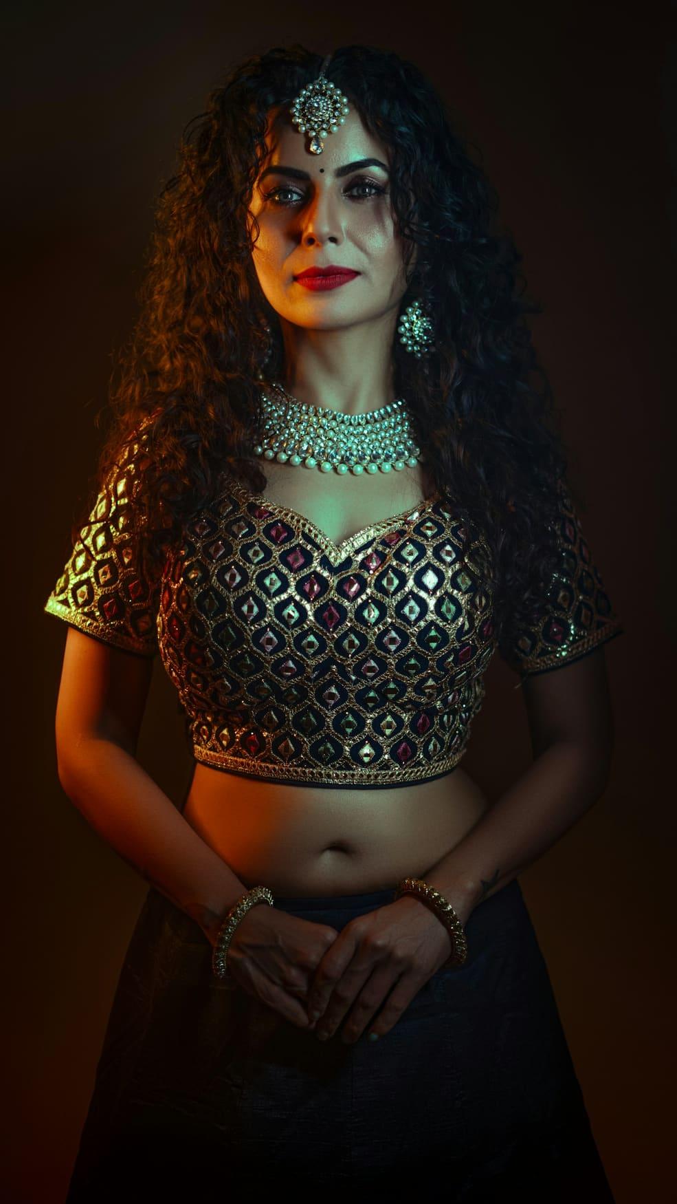 Woman in a black and gold embroidered lehenga choli